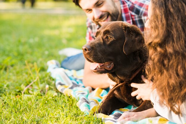 Close-up of a couple with their dog in park