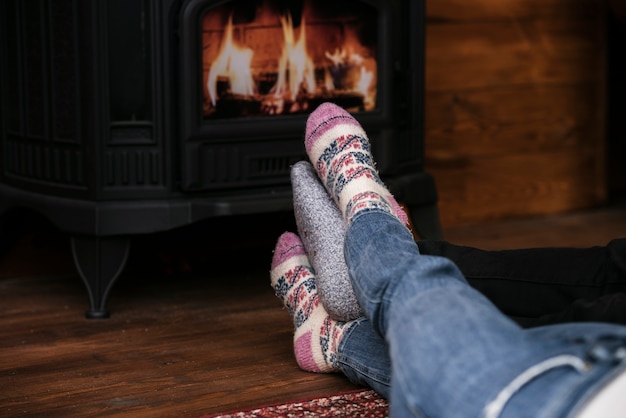 Free photo close-up couples feet next to fireplace