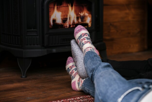 Close-up couples feet next to fireplace