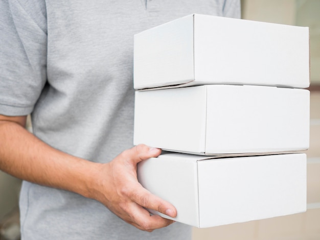 Close-up courier holding white boxes