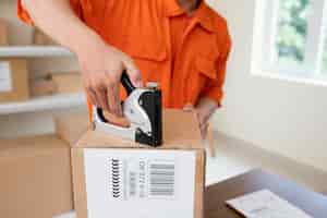 Free photo close up on courier preparing package for delivery