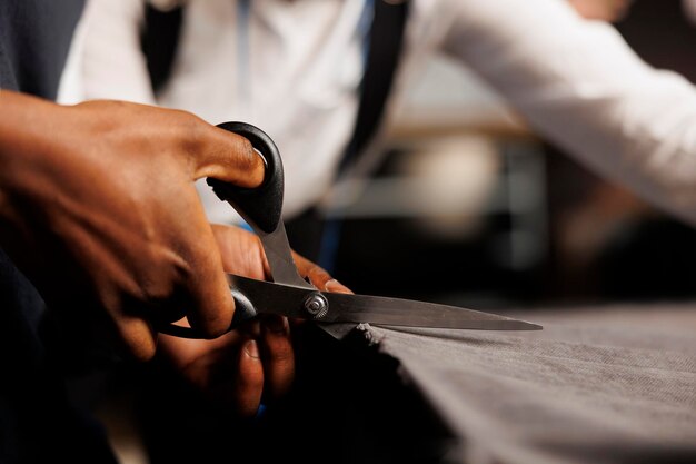 Close up of couturier using scissors