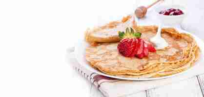 Free photo close-up of crepes with cream and strawberries