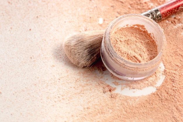 Close-up of crushed mineral shimmer powder golden color with makeup brush