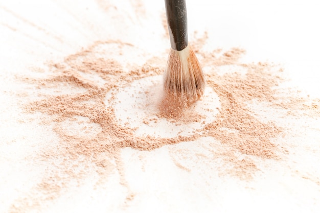 Close-up of crushed mineral shimmer powder golden color with makeup brush