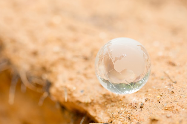 Free photo close up of crystal globe resting on mud.