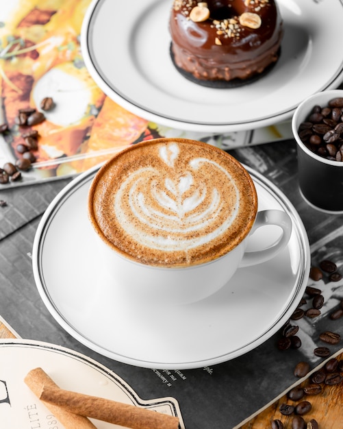 Close up of cup of cappuccino coffee and chocolate cake