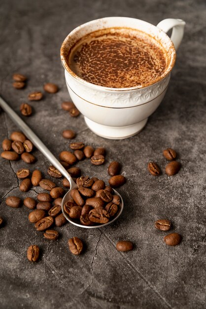Close-up cup of coffee with roasted beans