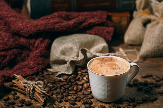 Close-up cup of coffee with roasted beans