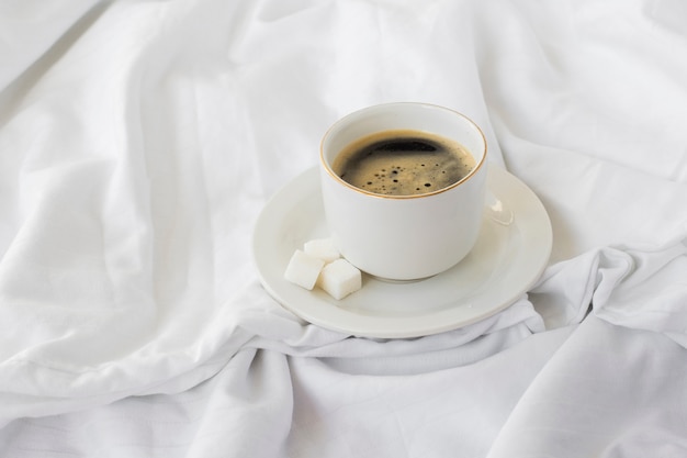 Close-up cup of coffee with sugar cubes