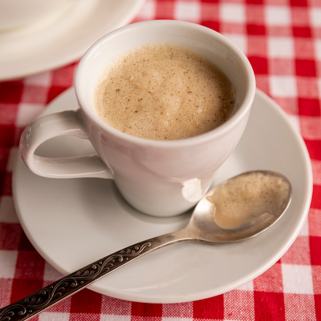 체크 무늬 배경으로 밀크 커피의 근접 컵