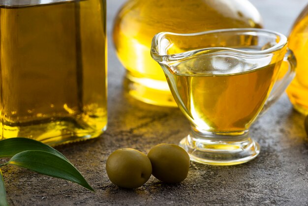 Close-up cup of olive oil and green olives