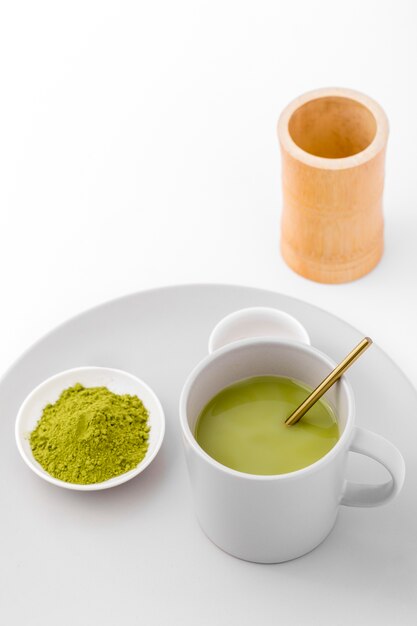 Close-up cup with matcha tea and powder