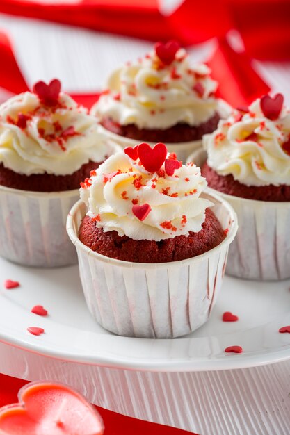 Close-up of cupcakes with heart-shaped sprinkles and candle