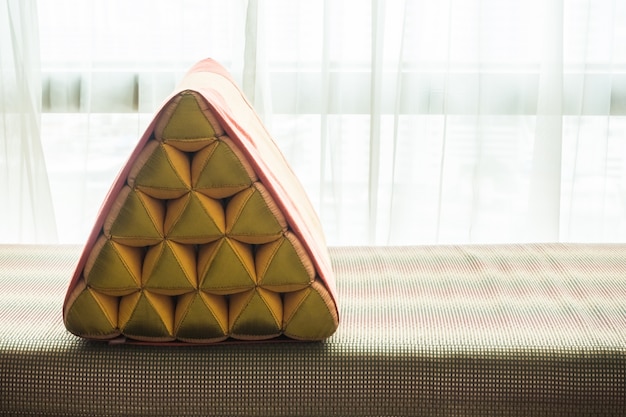 Close-up of cushion with white curtains background