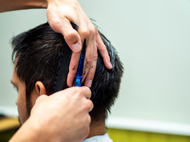 Close-up of customer getting a cut from behind