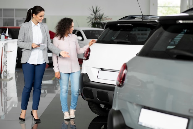 Foto gratuita primo piano sul cliente con un uomo d'affari in una concessionaria d'auto