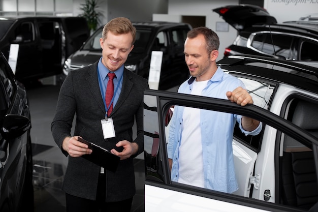 Close up on customer with business person in car dealership