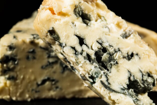 Крупный план вырезать синий сыр с плесенью внутри