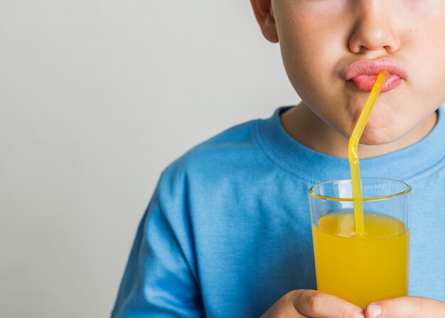 クローズアップかわいい子供のジュースを飲む