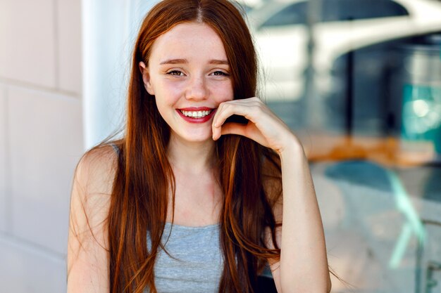 Close up cute portrait of pretty redhead woman , with amazing long hairs, fresh natural make up, big smile and eyes, pastel soft colors, tender sensual mood.