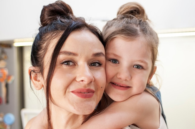 Close-up cute young girl hugging mother