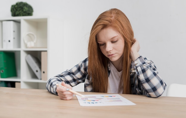 Free photo close-up cute young woman reading a paper