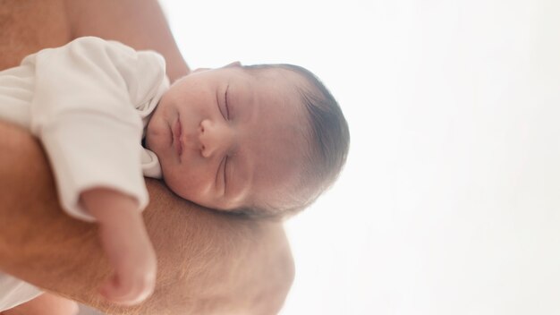 Close-up dad holding baby on his arm