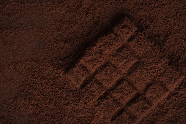 Foto gratuita primo piano di una barretta di cioccolato fondente ricoperta di cioccolato in polvere