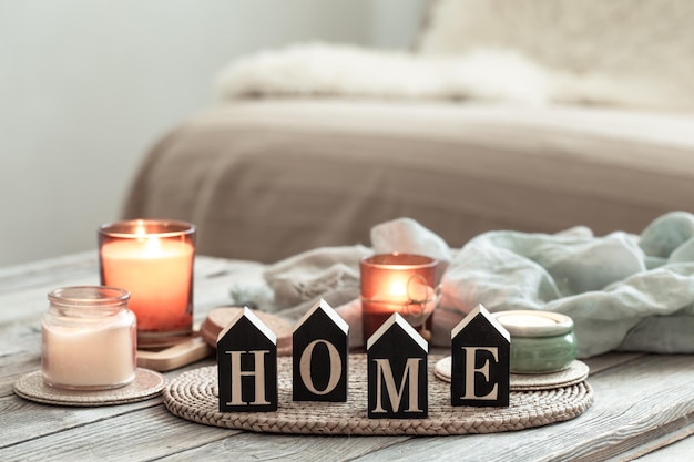 Free photo close up decorative word home on blurred background with candles