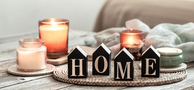 Close up decorative word home on blurred background with candles