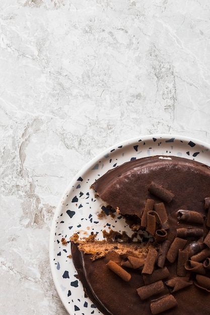 Close-up of delicious chocolate cake on white dish over marble backdrop