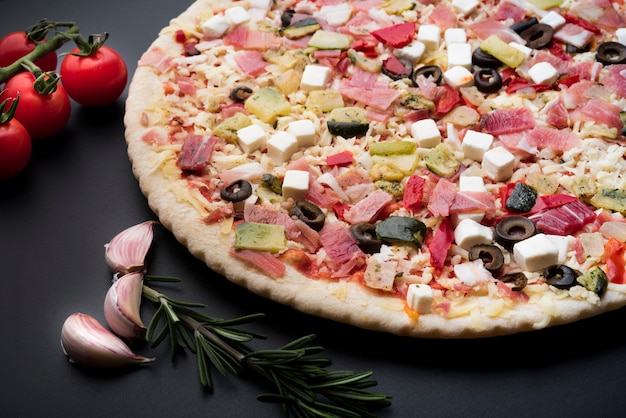 Close-up of delicious fresh italian pizza on black background