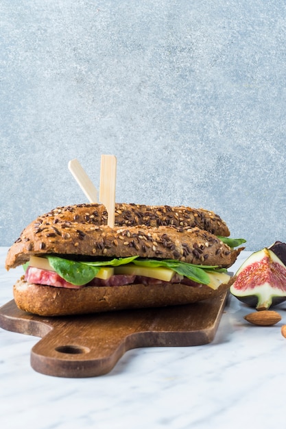 Free photo close-up of delicious hot dogs with fig slices and almond on wooden chopping board over kitchen counter