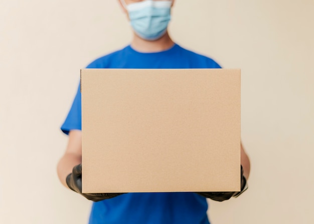 Close-up delivery man holding box