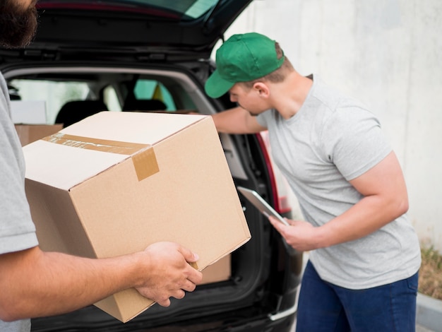 Close-up delivery man holding clipboard