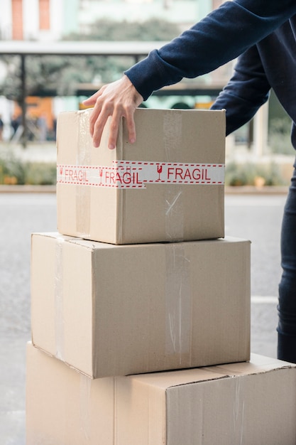 Close-up of a delivery man's hand picking up cardboard box