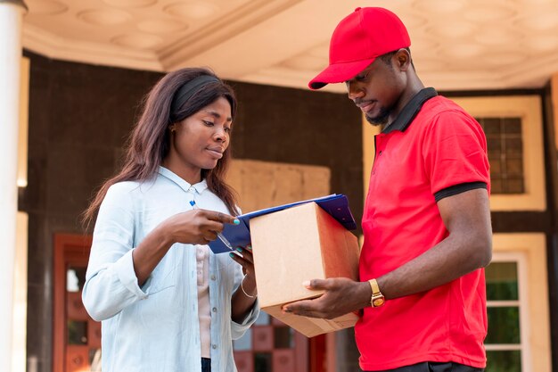 Close up on delivery person giving parcel to client