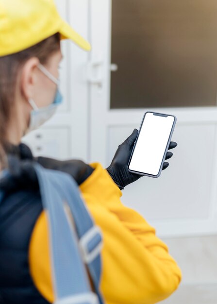 Close-up delivery woman holding phone