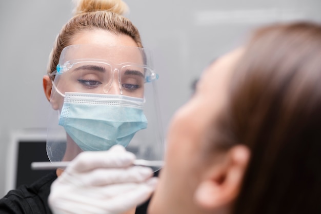 Close up dentist helping patient