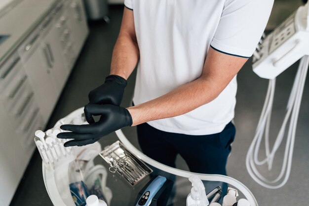 Close-up of dentist putting on surgical gloves