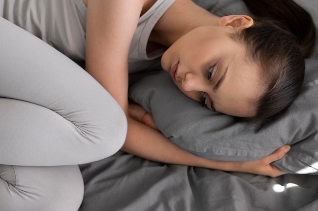 Close up depressed woman in bed