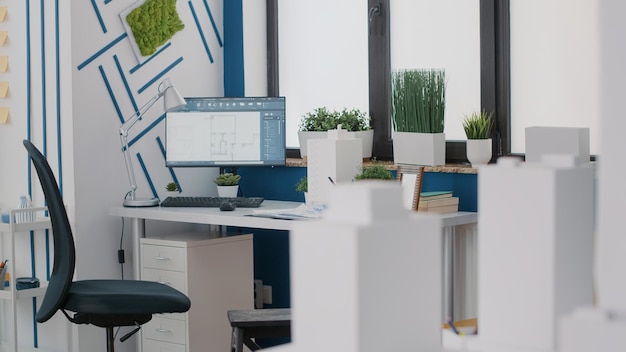 Close up of desk in architectural office with digital blueprints plans on computer. Monitor with sketch presentation for building layout and structure. Architecture urban project