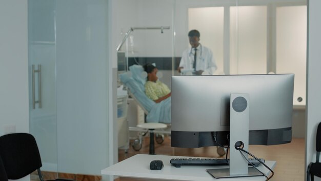 Close up of desk with computer in hospital ward clinic to check patient information and files. Space with monitor used for online medical documents and healthcare system. Emergency room