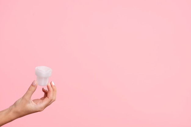 Close-up detergent cup with pink background