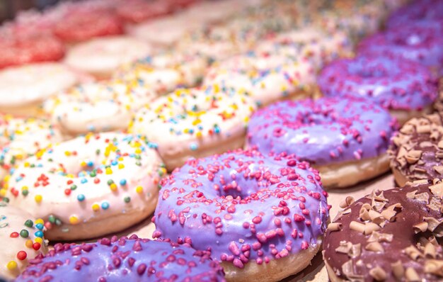 Close up of different donuts with sugar frosted glaze and sprinkles