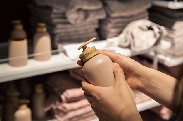 Close up a dispenser for liquid soap in female hands in the store