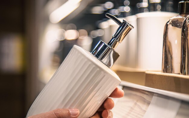 Close up a dispenser for liquid soap in female hands in the store