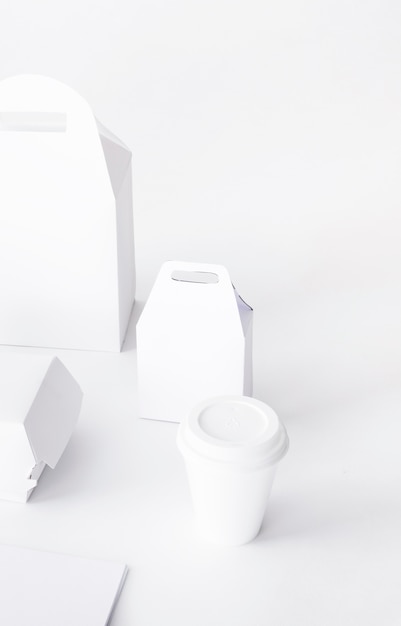 Close-up of disposal cup and food parcel mock up on white background