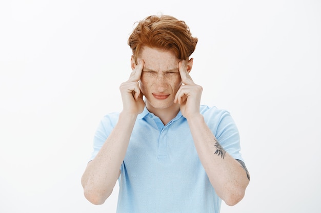 Free photo close-up of distressed redhead college student trying to focus, feeling dizzy, have headache